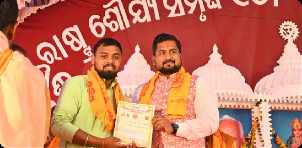 Rajesh Kumar Gouda being presented with a framed certificate on stage by Suryabanshi Suraj, Minister of Sports and Youth Services, Government of Odisha