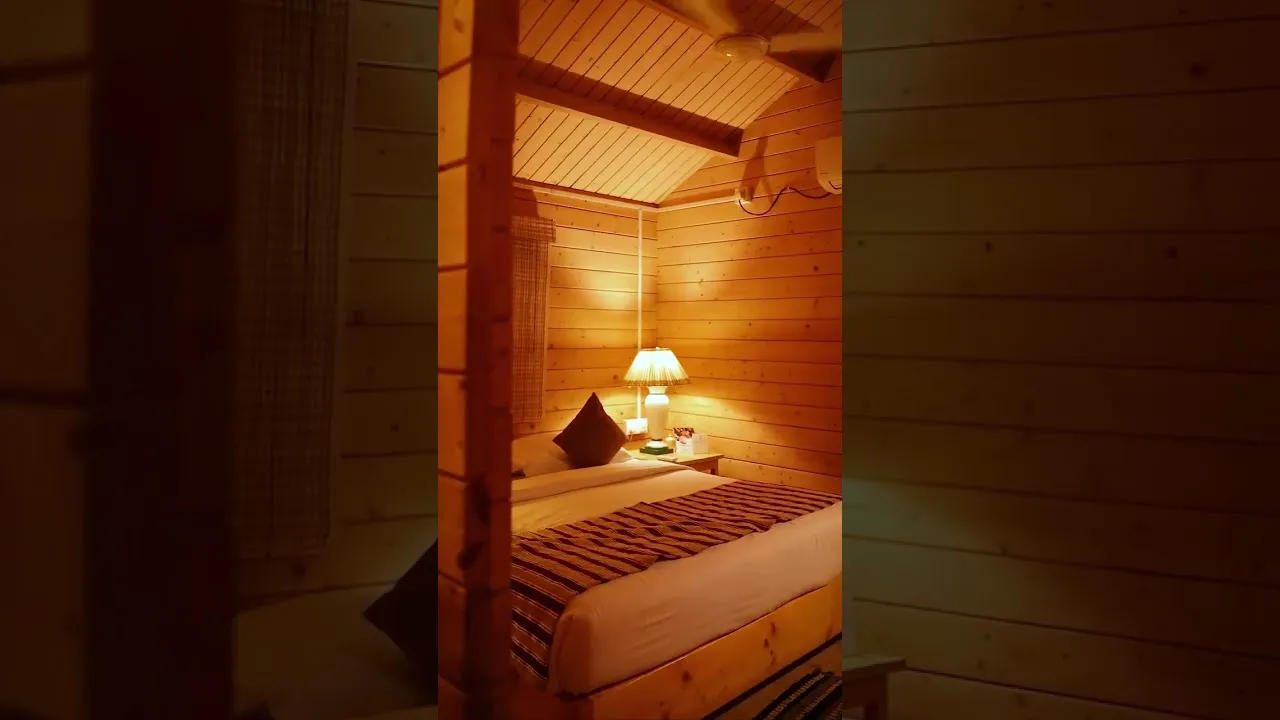 A timber-panelled bedroom lit by a bedside lamp, from a commercial property shoot