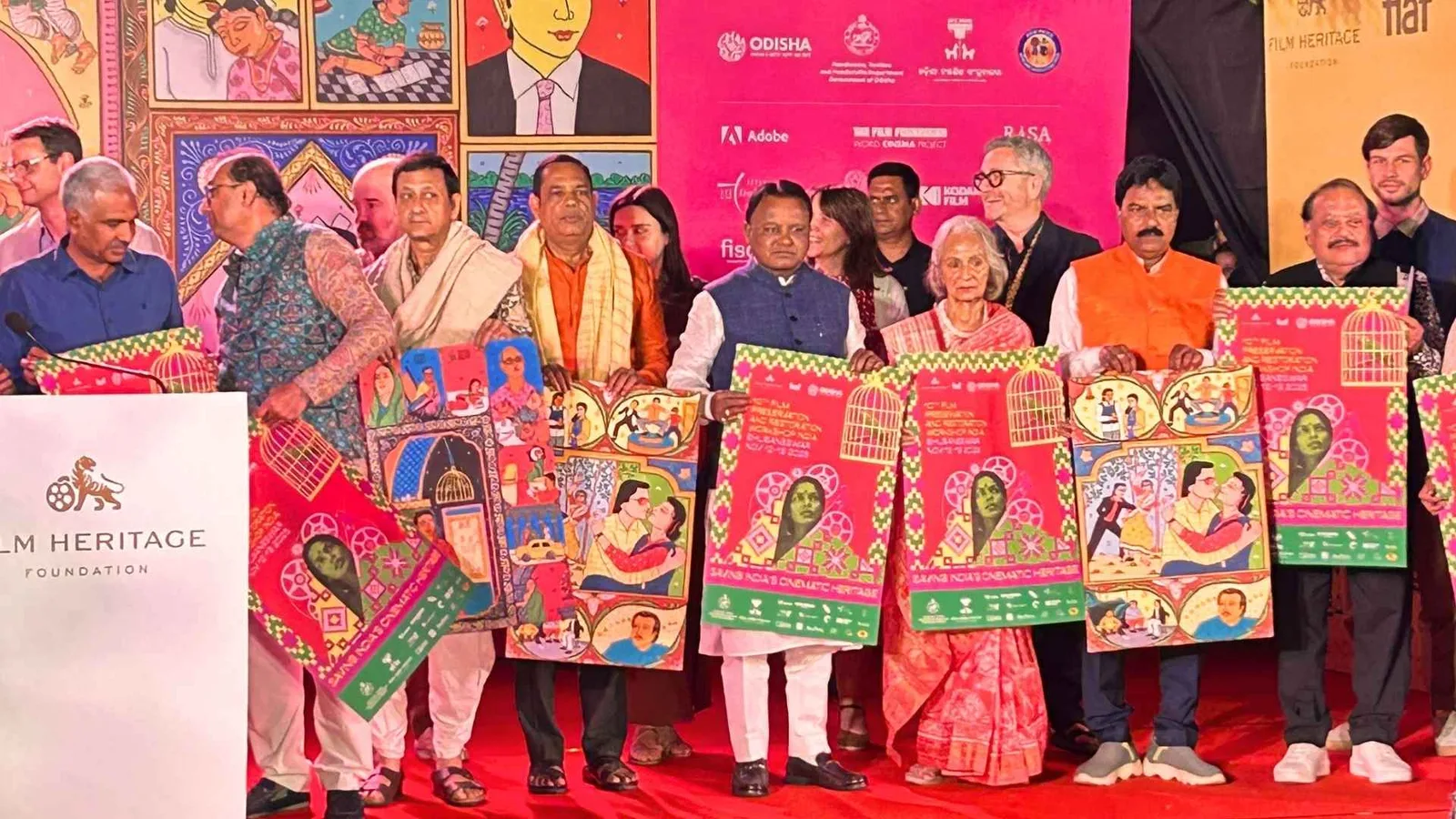 Delegates on stage holding printed artwork at the Film Heritage Foundation workshop, framed prints displayed behind them